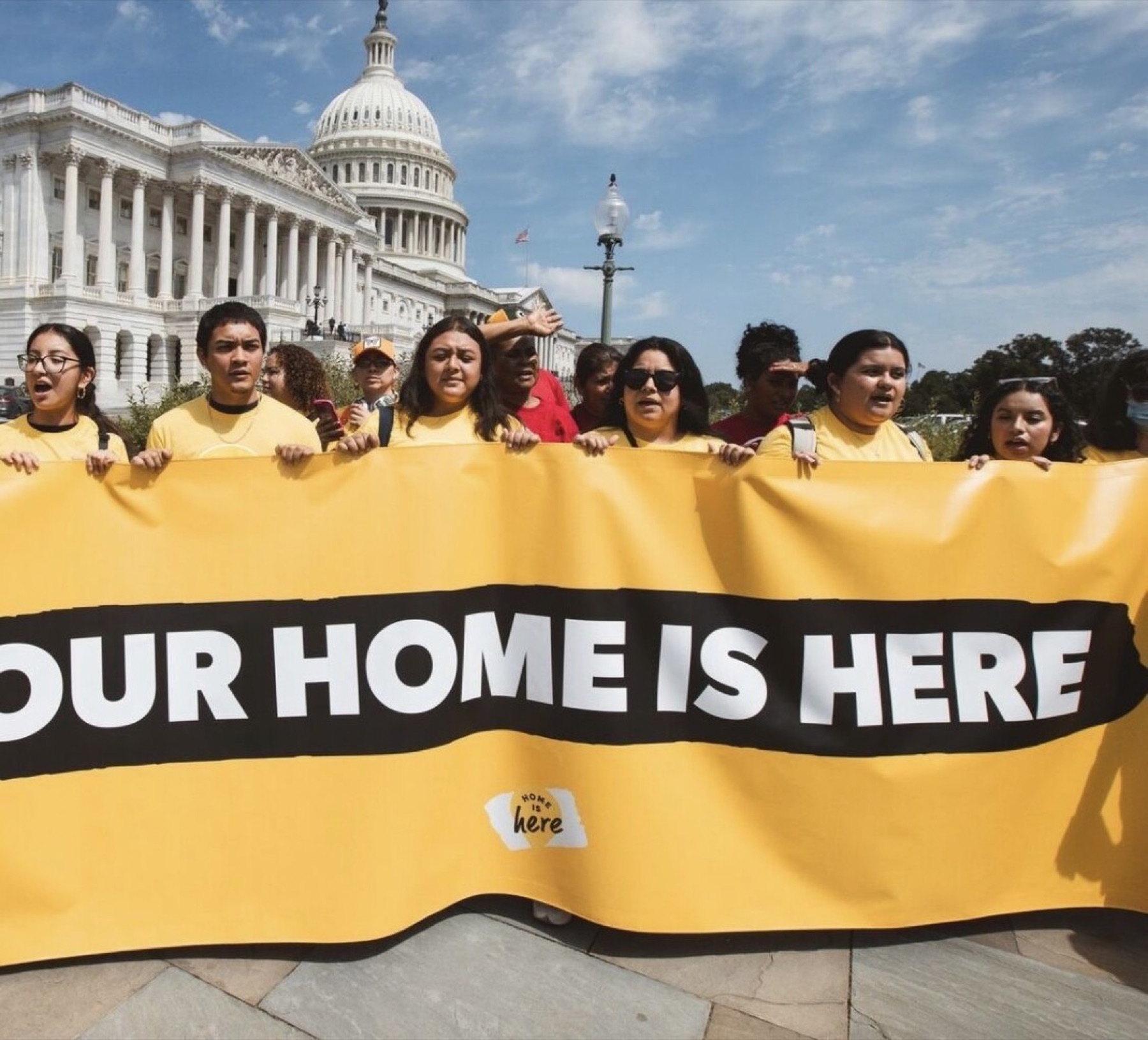 Rosa J. Bello with immigrant advocates holding an Our Home Is Here banner at the U.S. Capitol